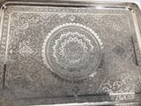 a silver tray with a decorative design on it