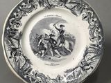 an old plate with a picture of a man riding a horse on it