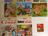 Plusieurs albums de bandes dessinées sont alignés sur une surface blanche