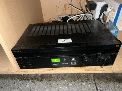 a black box with a green label on it sitting on a shelf