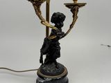 an antique bronze and marble candelabra with a boy holding a candelabra on a marble base
