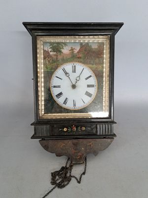 Pendule murale en bois noirci et verre églomisé et à décor e…