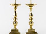 a pair of brass candlesticks on a white background