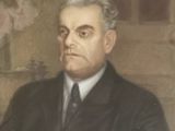 portrait d'un homme en costume-cravate, assis devant un tableau