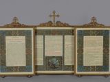 an open book with a cross on top of it sitting on top of a table