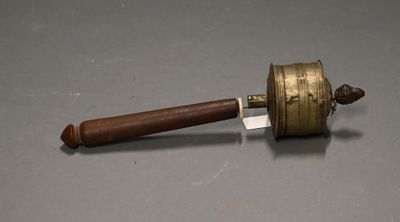 a small brass bell with a wooden handle on a table