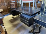 un bureau avec une chaise et un cadre photo posé dessus