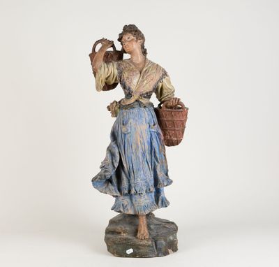 une vieille statue représentant une femme tenant un panier et une cruche
