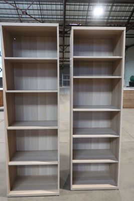 two empty bookshelves in a warehouse with one open and the other closed