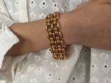 a woman wearing a white shirt and a gold bracelet