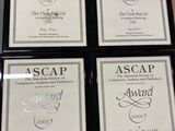 four framed awards are sitting on a table in front of a wall
