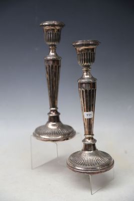 pair of silver candlesticks on clear acrylic stand