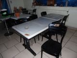 une table et des chaises dans une pièce, avec une bâche bleue posée sur la table