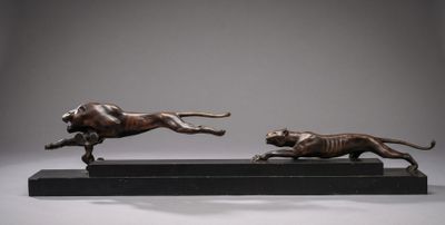 two bronze statues of a dog and a cat running on a black base