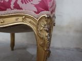 a pink and gold chair with a pink cushion on it