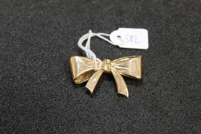 a gold bow with a tag on it on a black surface