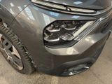 the front end of a car with a denting dent on it ' s bumper