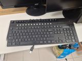 a computer keyboard and a monitor on a desk