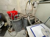 a red bucket sitting on top of two metal barrels