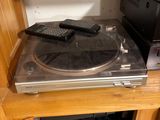 a record player sitting on top of a shelf next to a cd player