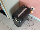 a black piece of luggage sitting on the floor next to a pink wall