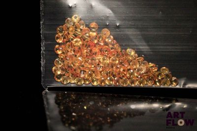 a pile of gold colored beads in a plastic bag