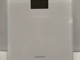 an image of a white electronic scale sitting on top of a table
