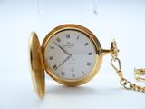 a gold pocket watch with roman numerals on it