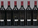 six bottles of wine are lined up in a row on a table