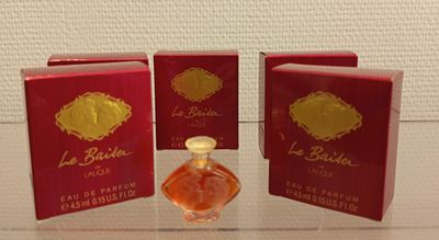 trois petits flacons de parfum posés sur une table en verre
