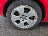 un gros plan d'une voiture rouge avec un pneu crevé