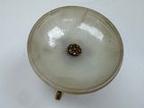 a small glass object with a gold decoration on it