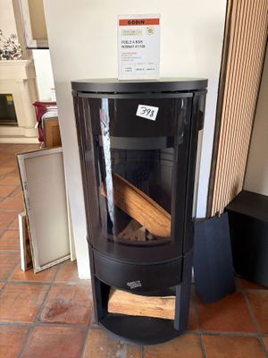 a black stove sitting in a room with a sign on the wall
