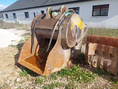 une photo d'un engin de chantier posé dans l'herbe
