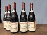 four bottles of wine are lined up on a wooden table