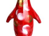 a red penguin figurine that is sitting on a white surface