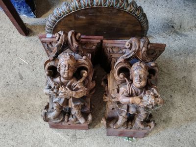 deux sculptures en bois posées au sol, l'une à côté de l'autre