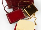 trois porte-monnaie en cuir rouge, dont l'un contient un bloc-notes et l'autre un bloc-notes
