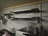 an image of a kitchen with a stove and shelves