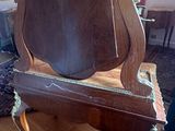a wooden chair with a mirror on it in a living room