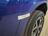 a close up of a blue car with a sticker on it