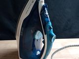 a blue and white iron sitting on a wooden table