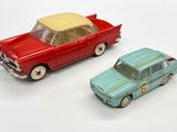 two toy cars sitting next to each other on a white surface