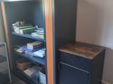 a black cabinet with a wooden door in a room