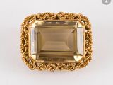 une bague en or sertie d'une émeraude entourée d'un motif en forme de corde