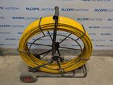 a yellow hose sitting on a cart with a wheel