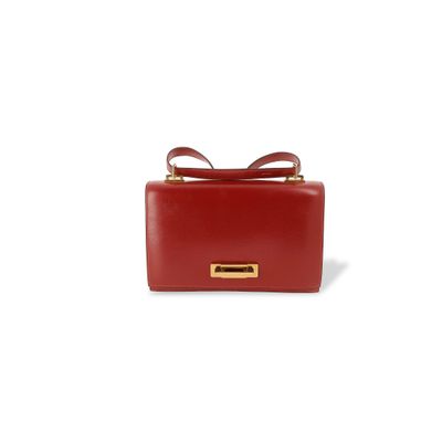 le petit sac rouge est posé sur une surface blanche