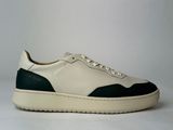 the white and green sneakers are on a white surface