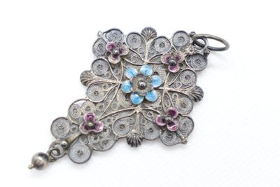 a close up of a silver broochet with pink and blue stones