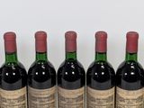 six bottles of red wine lined up in a row on a table